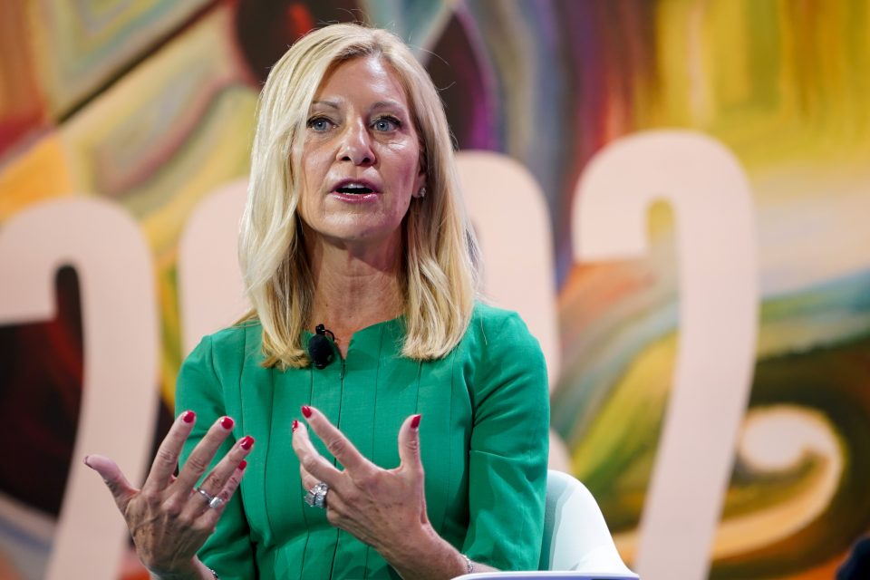 woman in green dress speaking onstage