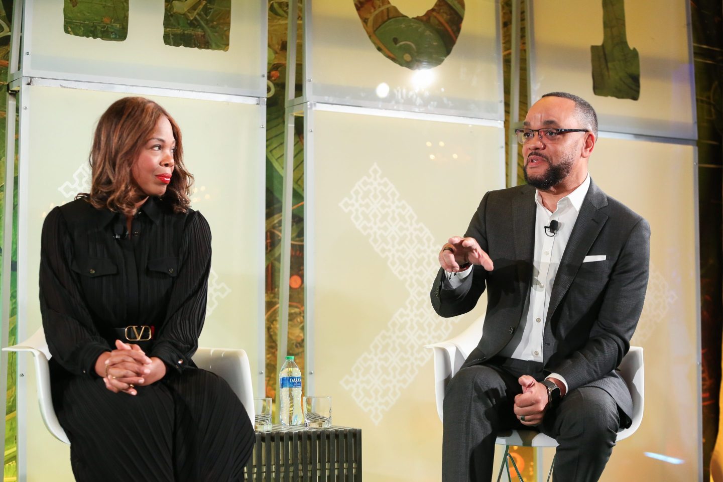 woman and man speaking onstage at a conference