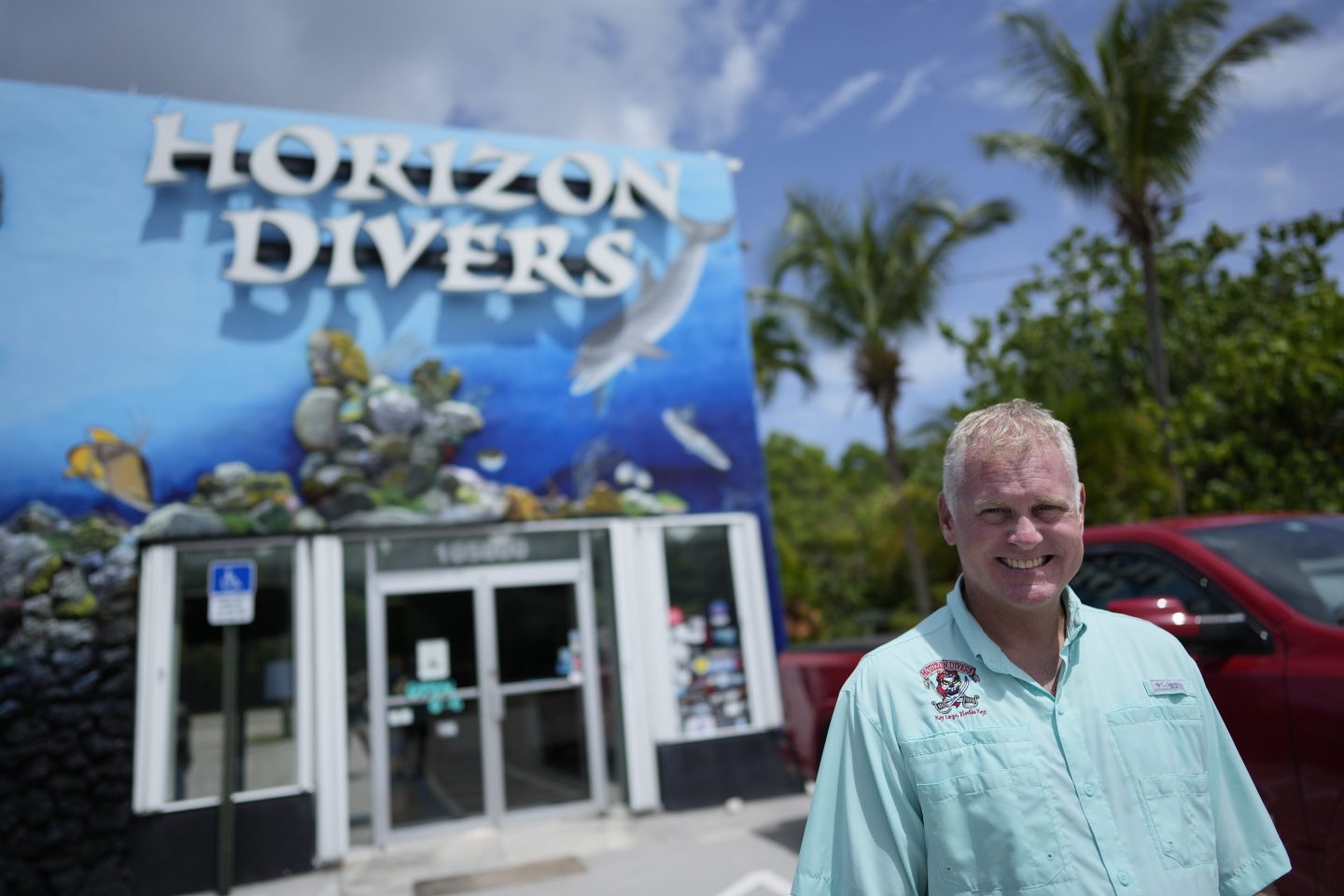 Dan Dawson, owner of Horizon Divers, poses outside his dive shop in Key Largo, Fla., Aug. 17, 2023.