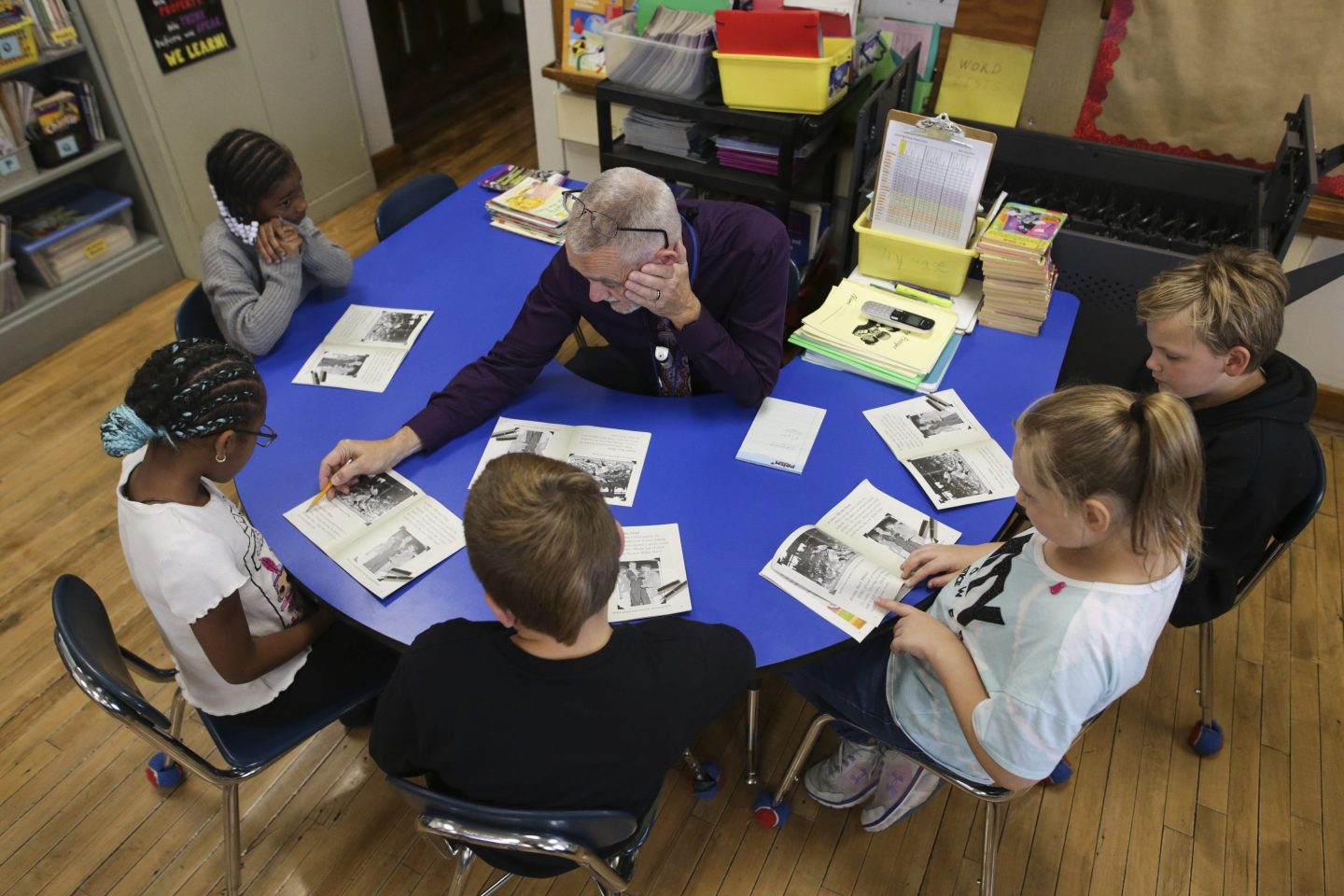 Richard Evans, a teacher at Hyde Park Elementary School, helps a student sound out a word during a reading circle in class in Niagara Falls, N.Y.