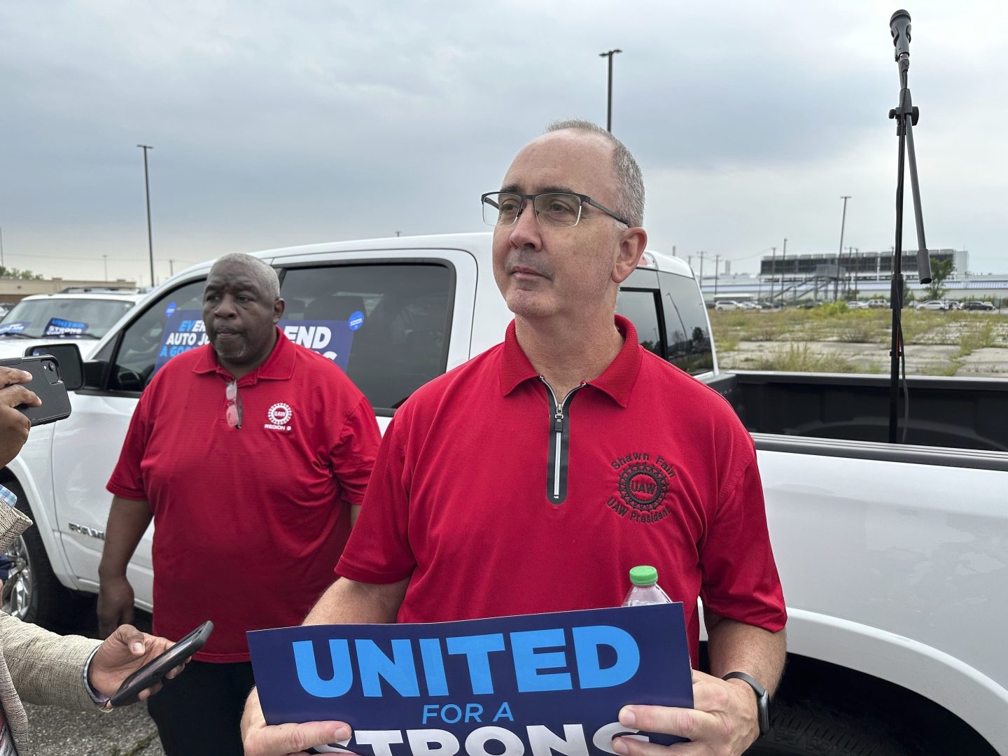 United Auto Workers President Shawn Fain holds up a sign at a union rally held near a Stellantis factory on Aug. 23, 2023, in Detroit.