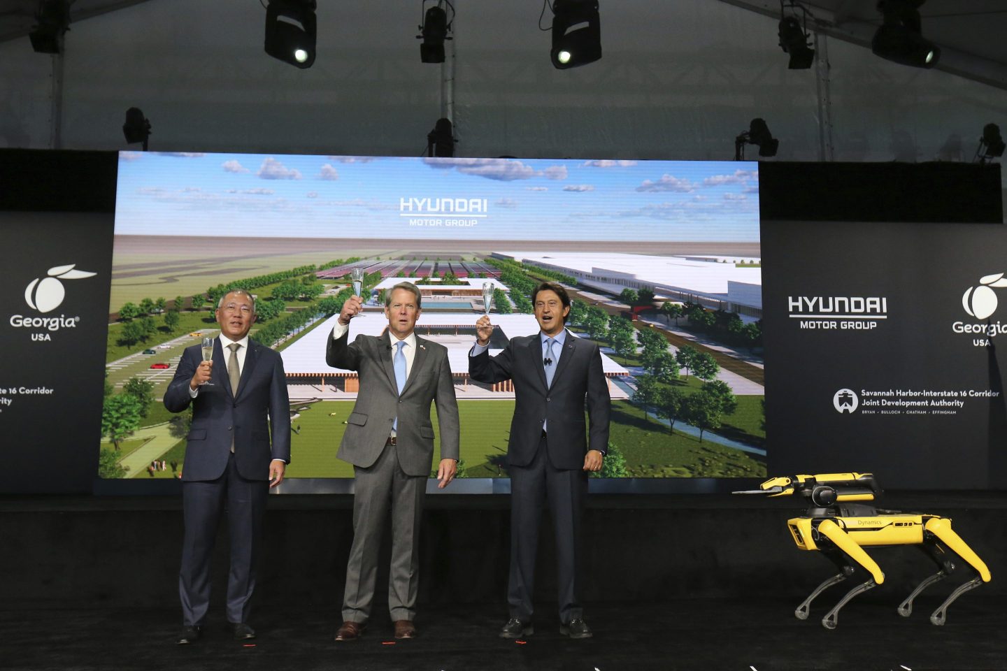Chung Eui-sun, left, executive chairman of Hyundai Motor Group, Georgia Gov. Brian Kemp, and Jose Munoz, president and COO of Hyundai, celebrate with a champagne toast during the official groundbreaking for the Hyundai Meta Plant on Oct. 25, 2022 in Ellabell, Ga.