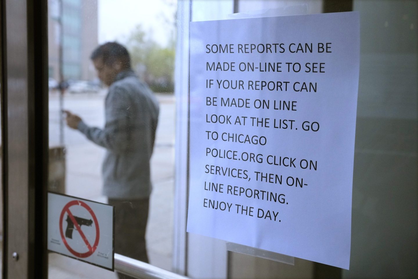 A migrant from Venezuela talks outside on a cell phone where he has taken shelter with others in the Chicago Police Department's 16th District station on May 1, 2023; 13,000 migrants have settled in Chicago the last year.