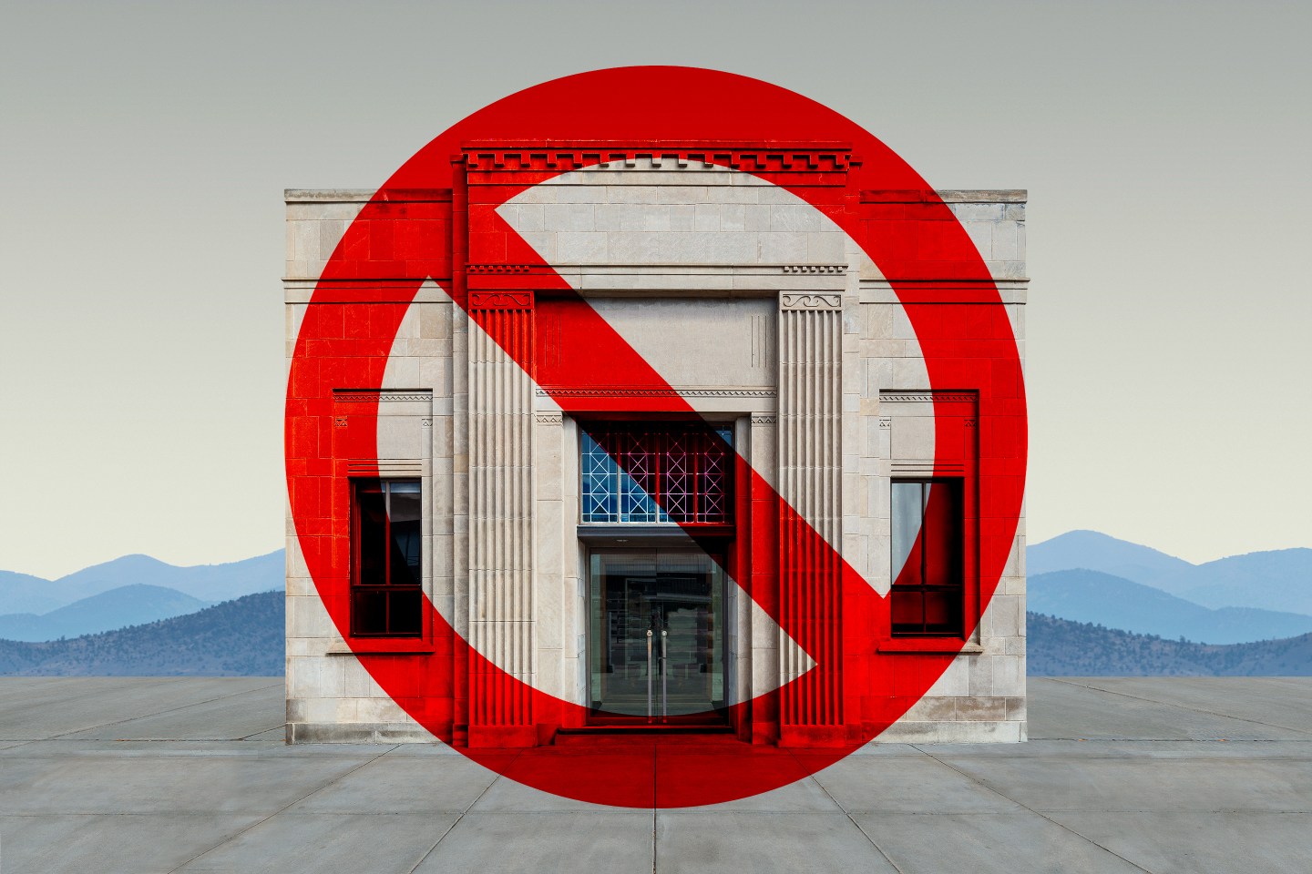 A 1930's bank building with Greek columns and imposing stature with a prohibit sign on top.