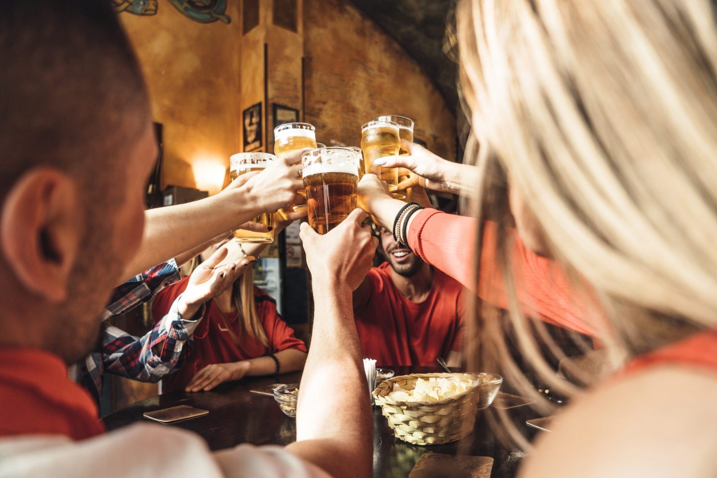 people cheers-ing to pints of beer