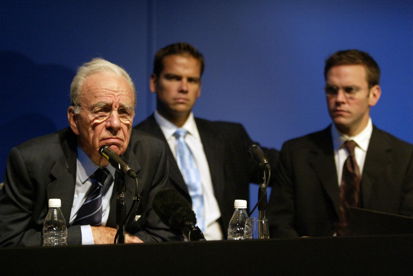 Rupert Murdoch with his sons Lachlan and James sitting behind him.