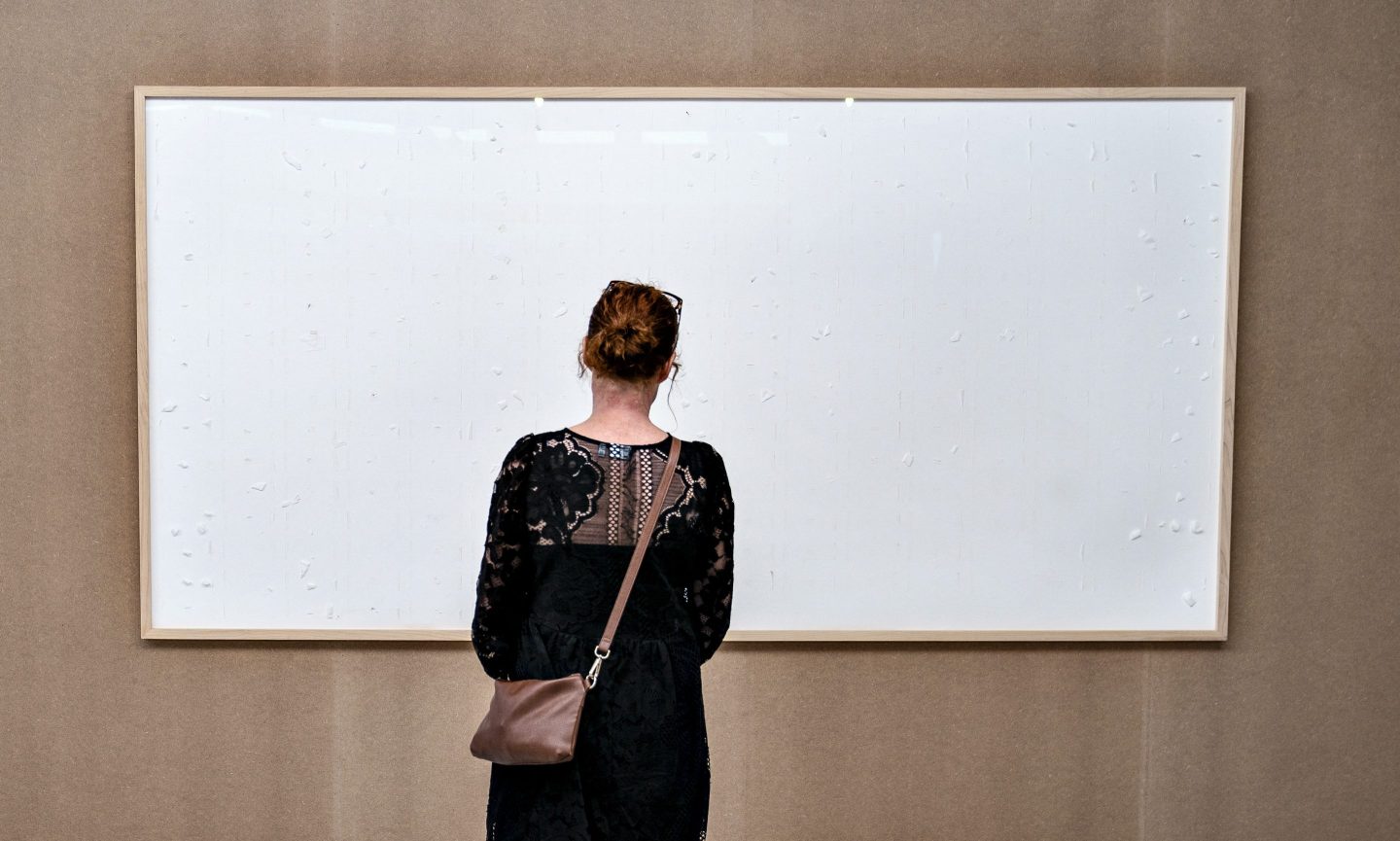 A woman stands in front of an empty frame hung up at the Kunsten Museum in Aalborg, Denmark, on Sept. 28, 2021.
