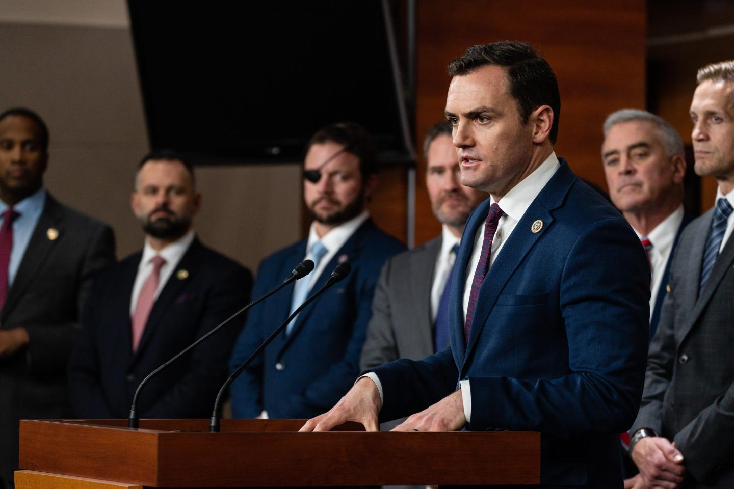 man in suit speaking at news conference