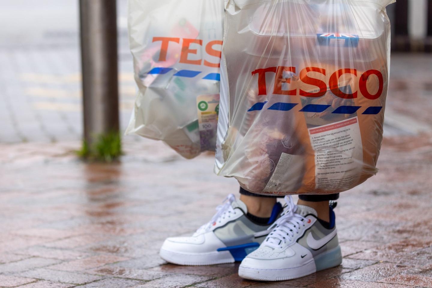 person holding tesco bags