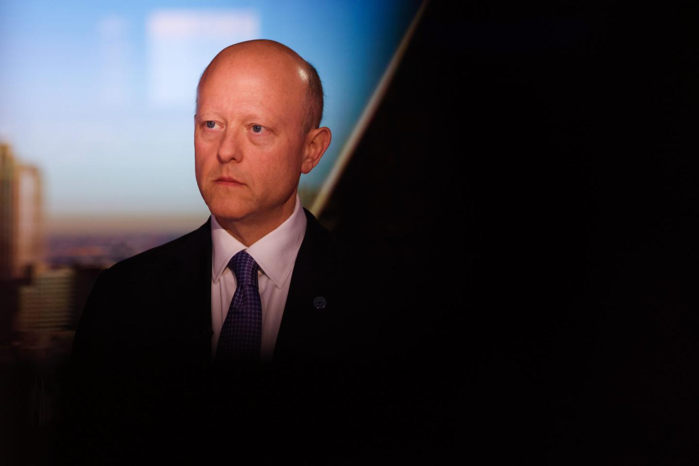 man in suit and tie partially obscured by shadow