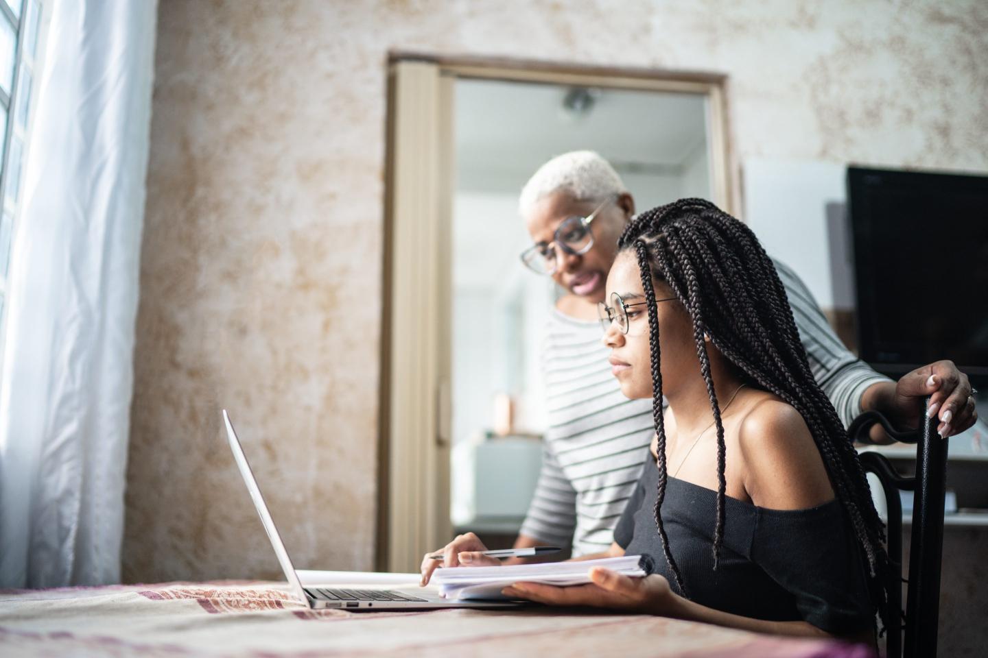 Mother and daughter studying with laptop on a online class at home
