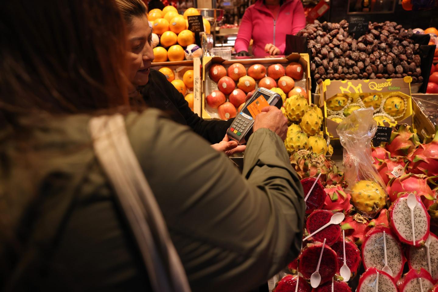 A person paying on card at a fruit and vegetable stall.