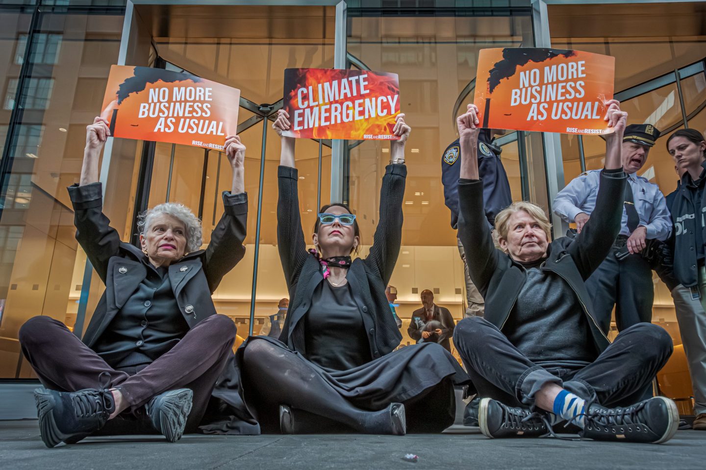 Protesters hold signs outside of BlackRock headquarters, demanding the investment firm to divest from fossil fuels.