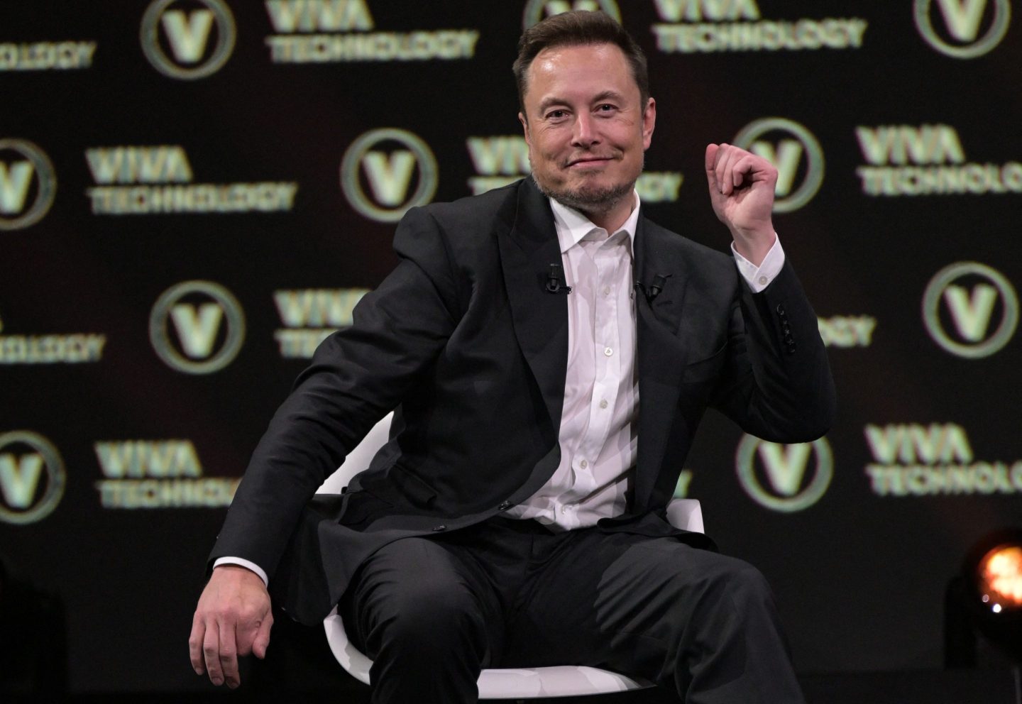 Elon Musk sitting in a chair dancing