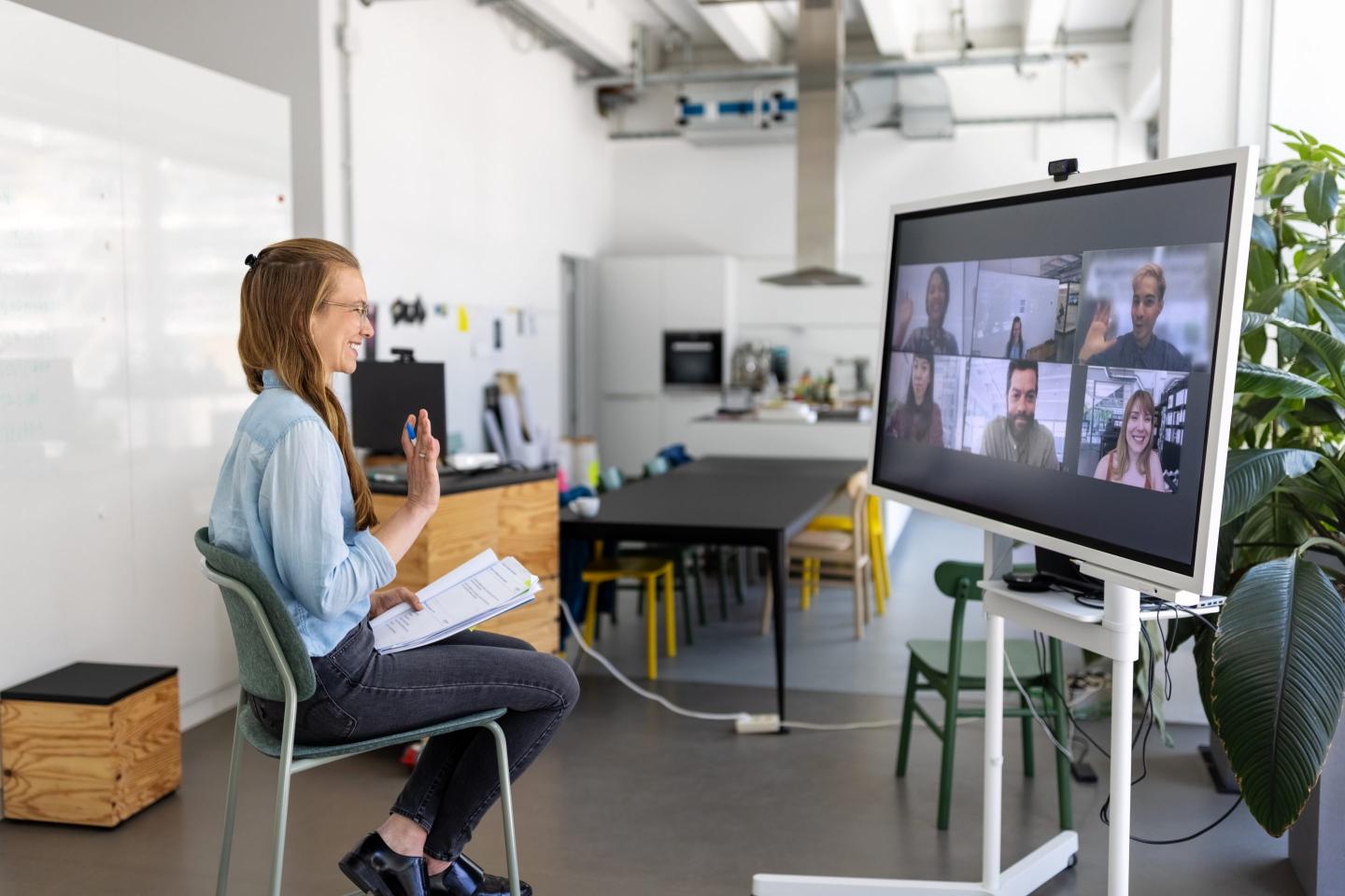 Female professional having online meeting with team