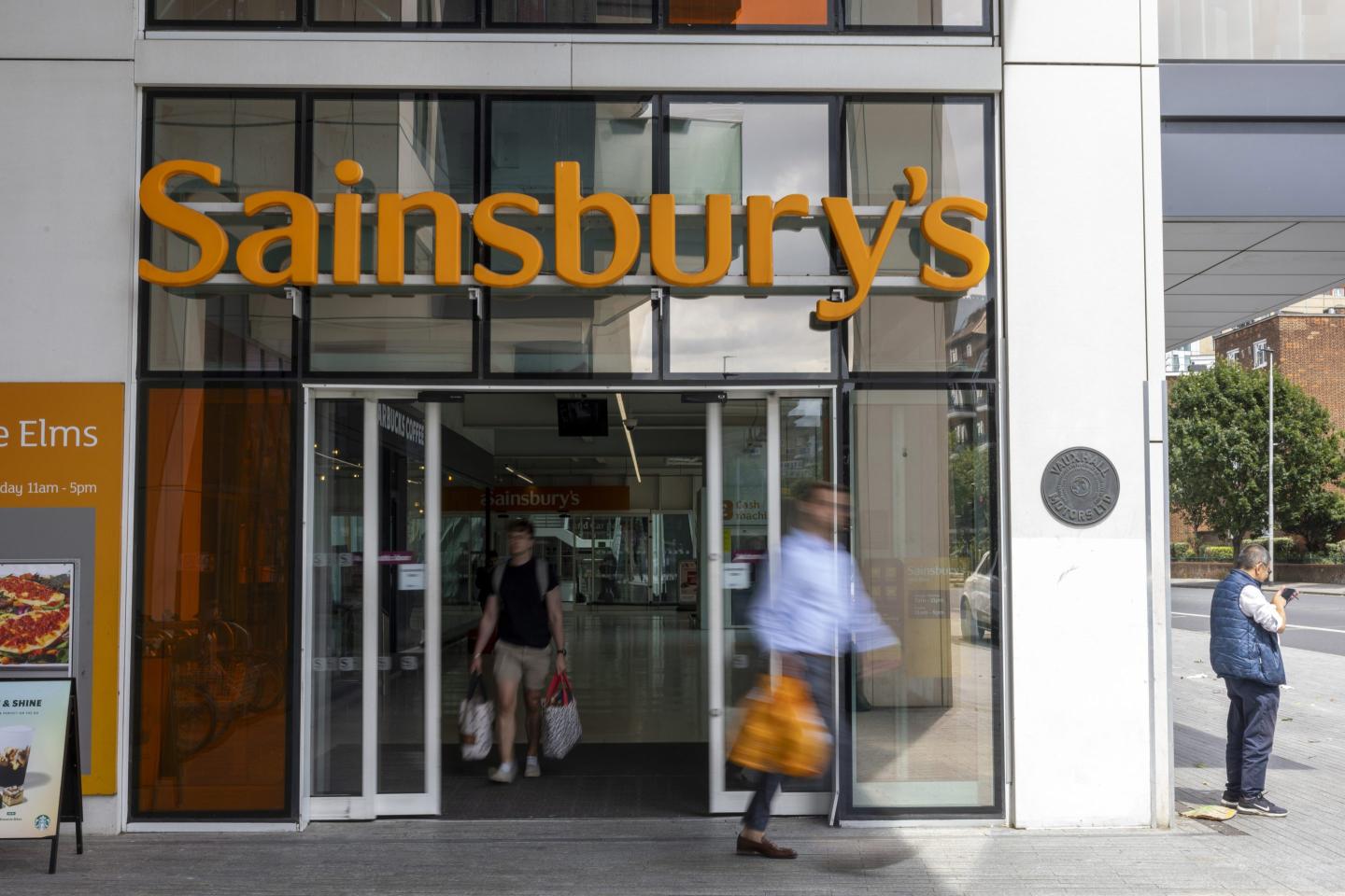 people walking out of a sainsbury's store