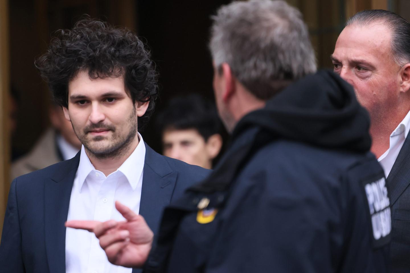 man in collared shirt and jacket exiting a court building