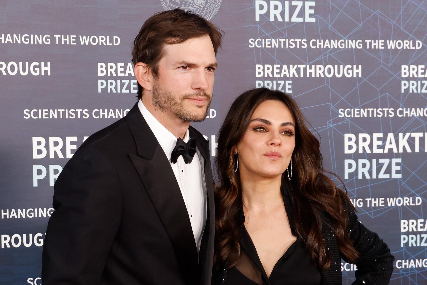 Mila Kunis and Ashton Kutcher pose at an awards ceremony.