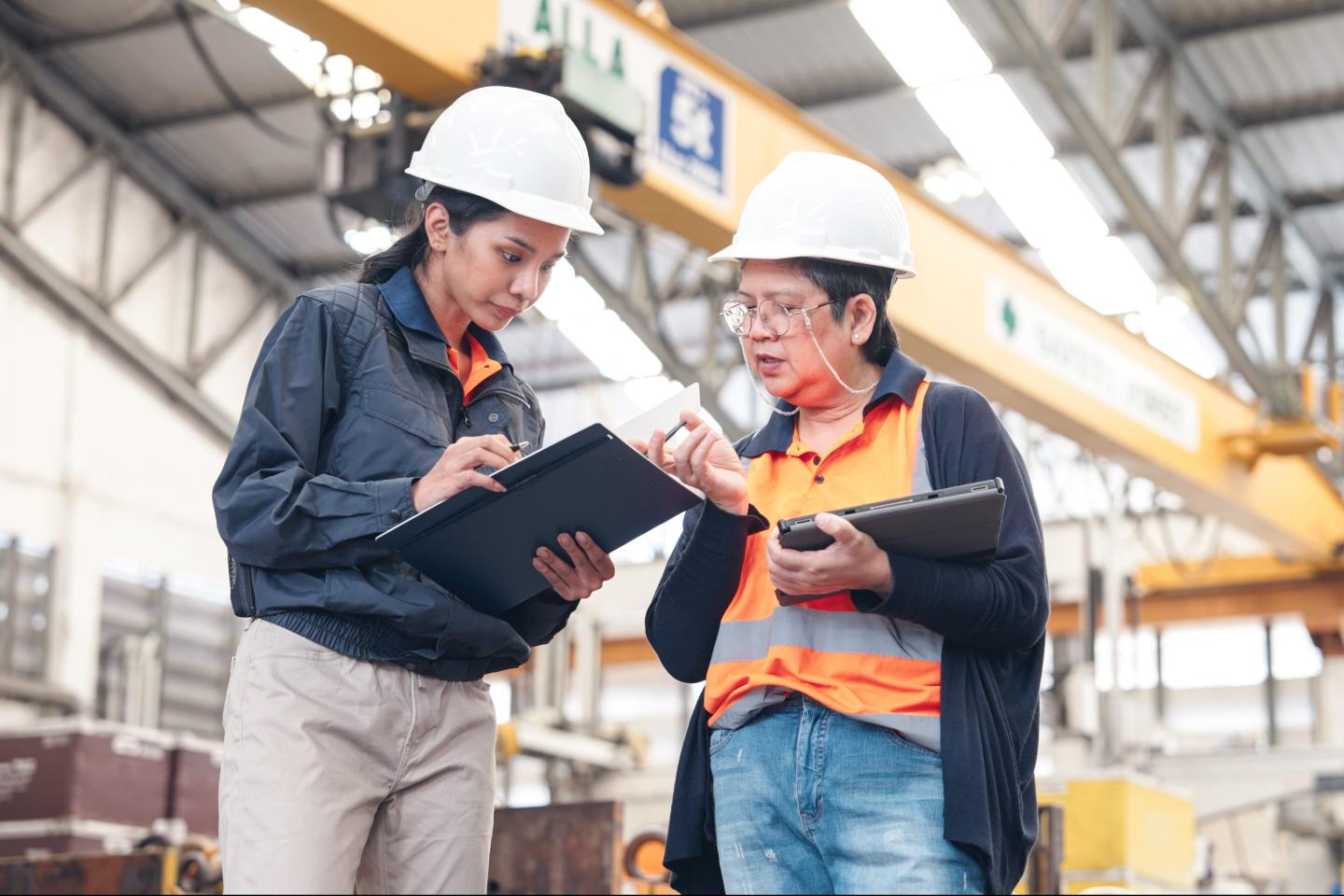 Senior female supervisor training engineer in factory.