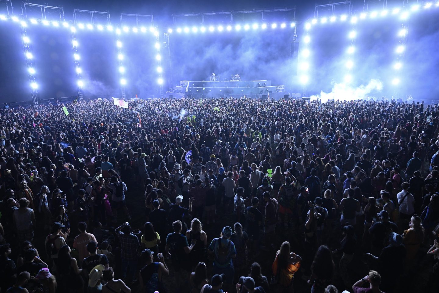 The crowd standing in front of an illuminated stage at Electric Zoo