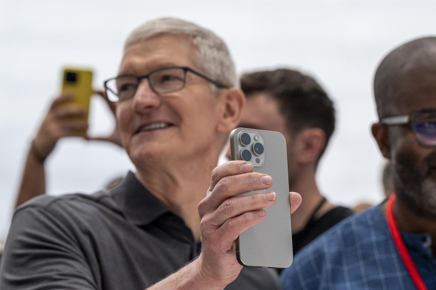 Apple CEO Tim Cook holding an iPhone 15 Pro.