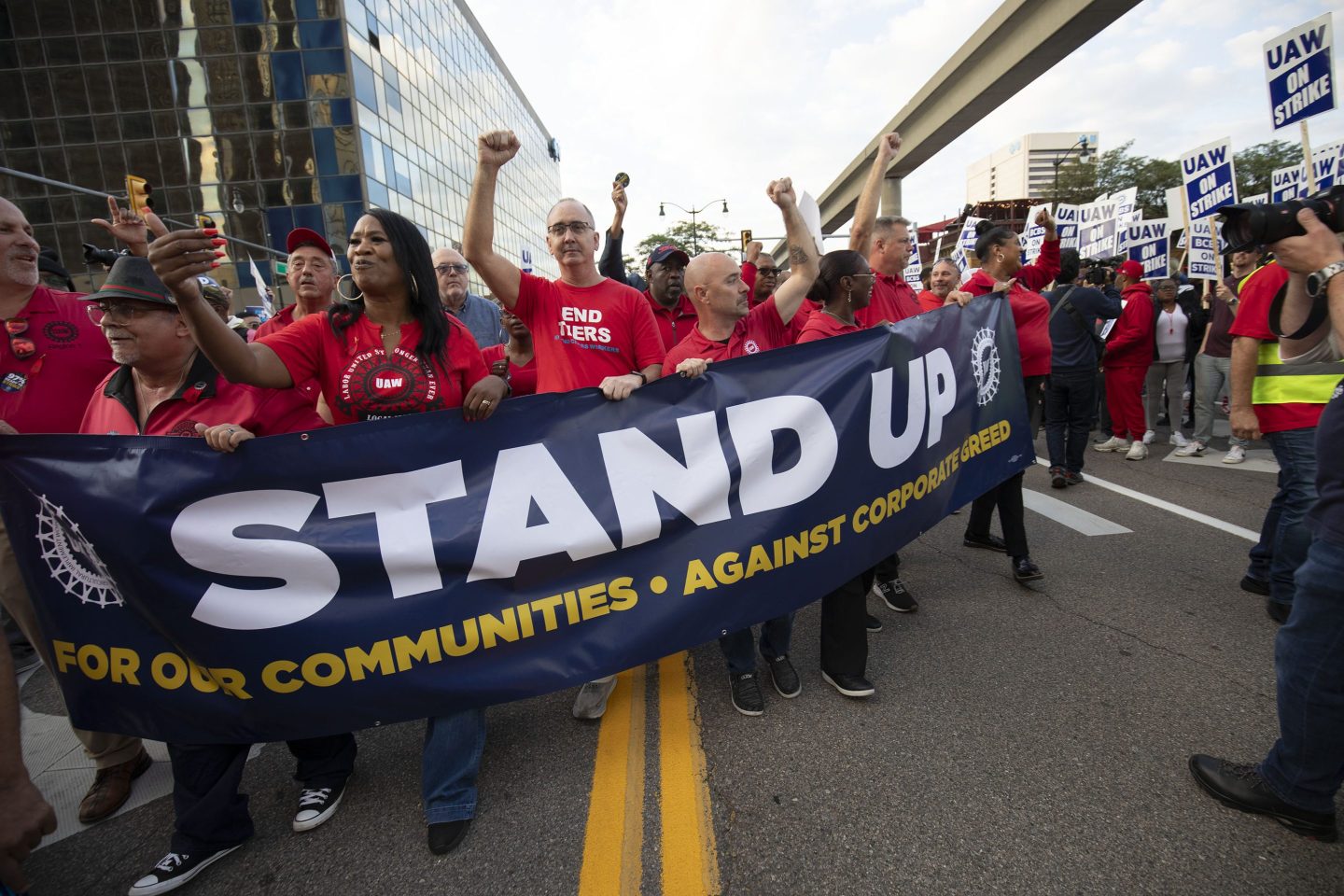 a crowd holding a banner and marching through the street