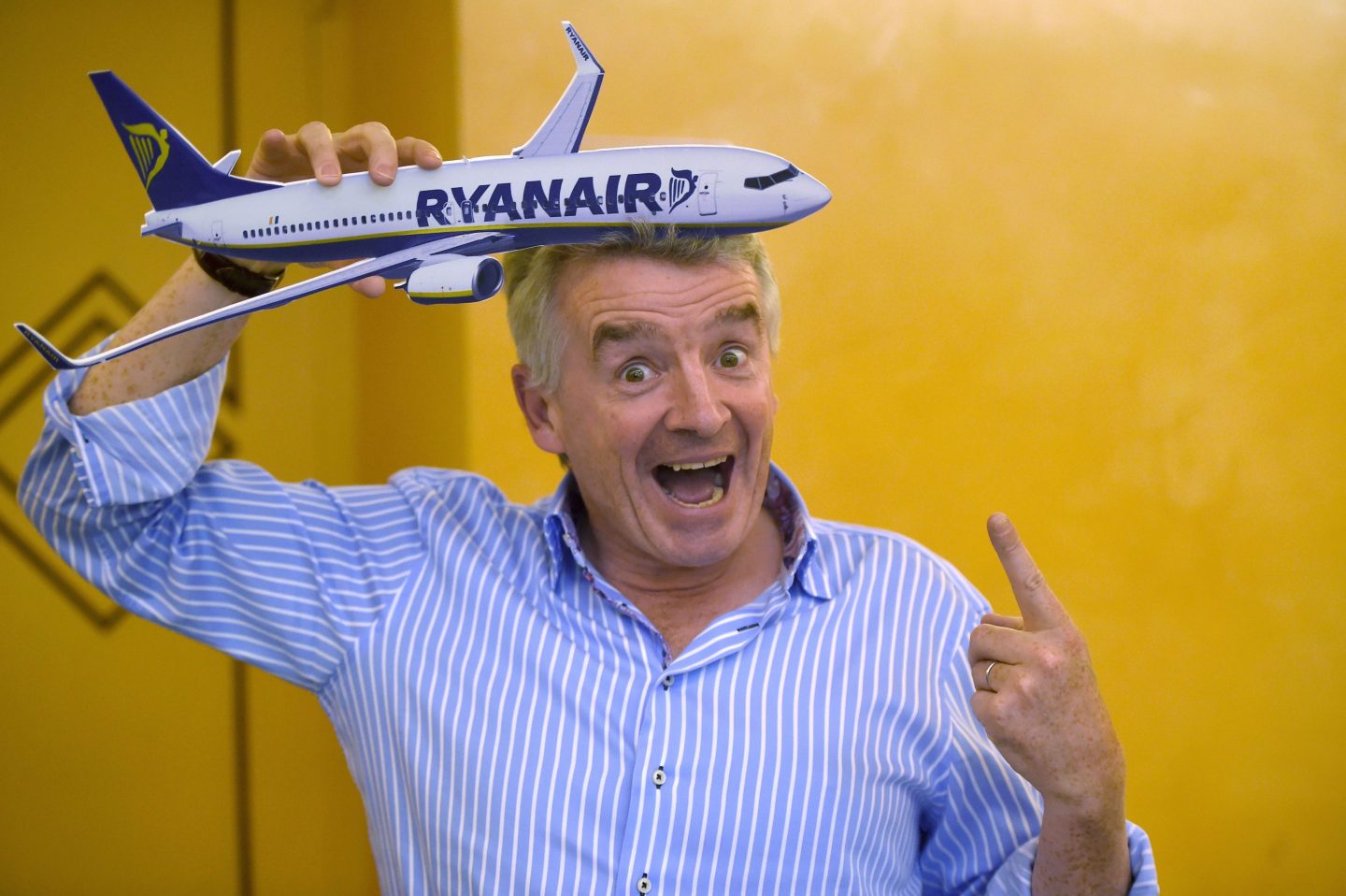 Ryanair CEO Michael O'Leary holding a model plane and smiling