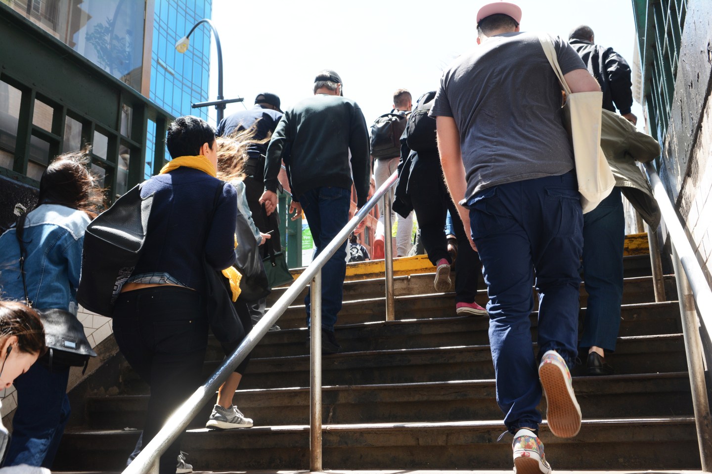Commuters walking upstairs, exiting a New York subway station.