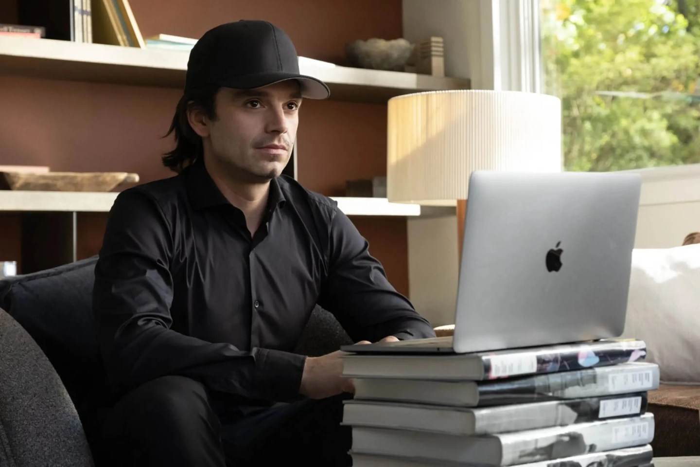 Man wearing black baseball cap sitting at a desk