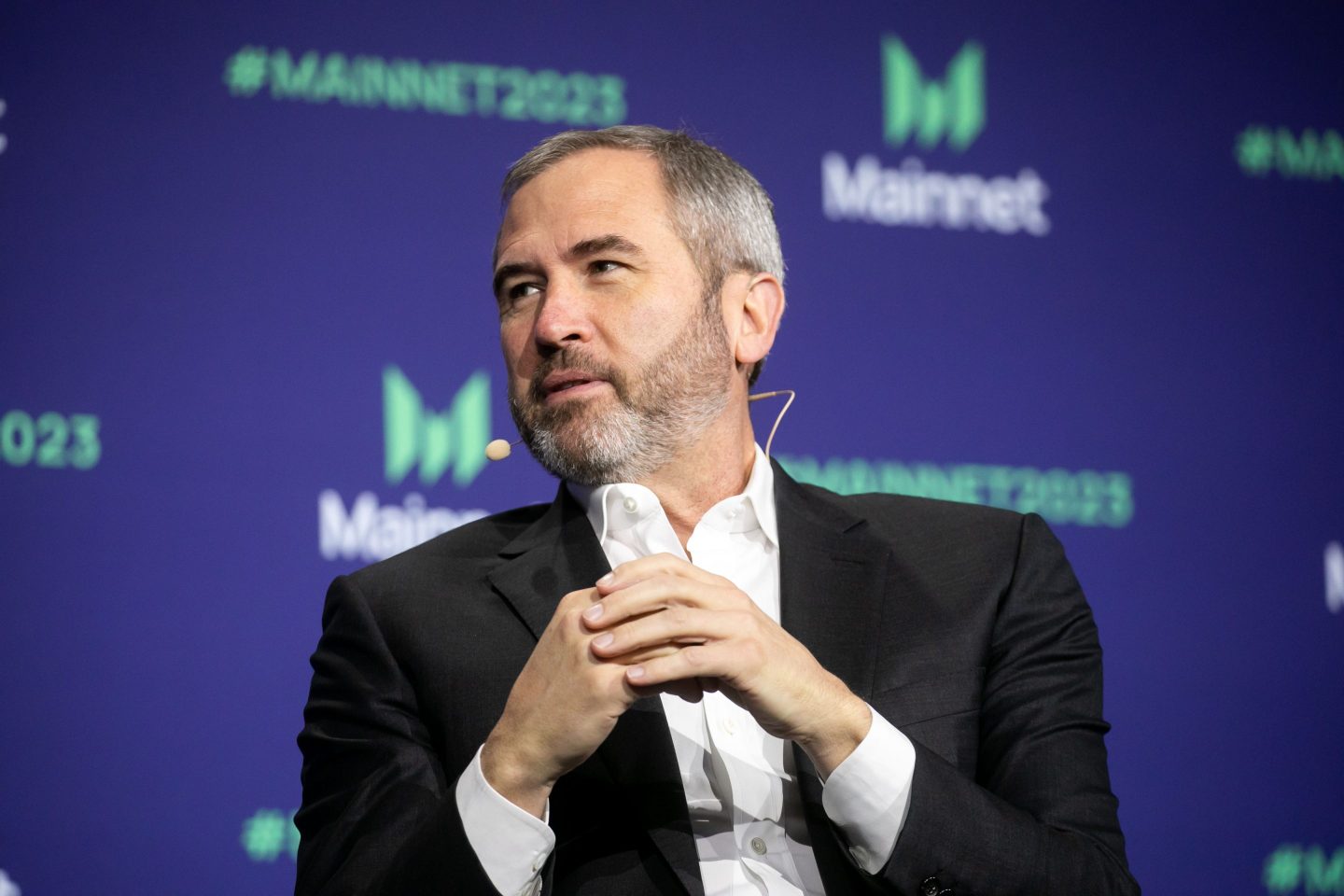 man in collared shirt and jacket speaking onstage