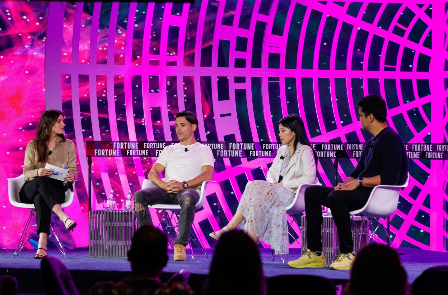 four business professionals sitting onstage