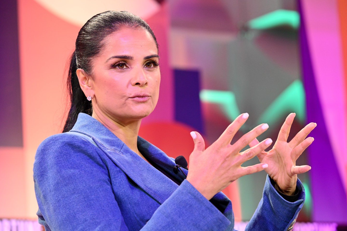 Bela Bajaria, Netflix's chief content officer, speaks on stage with hands splayed