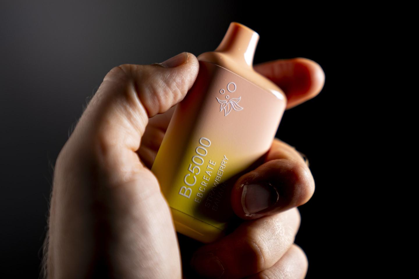 A hand holding an Elf Bar disposable vaping pod device.