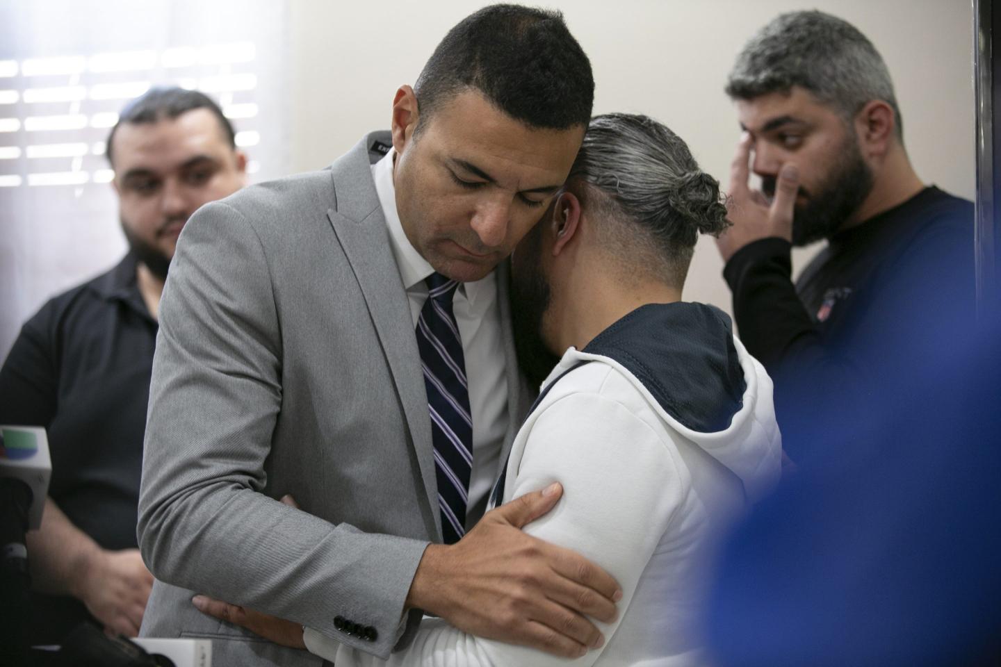 Ahmed Rehab, left, executive director of the Chicago chapter of the Council on American-Islamic Relations, embraces Odey Al-Fayoume, father of Wadea Al-Fayoume, 6.