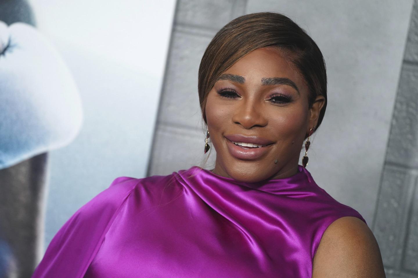 Serena Williams on the red carpet in a purple dress.