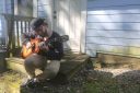 Man plays a guitar outside his apartment