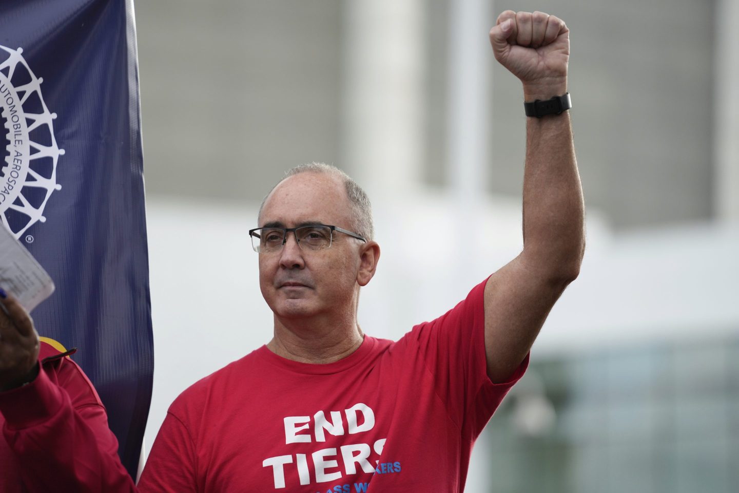 Shawn Fain raises a fist in a sign of solidarity at a rally