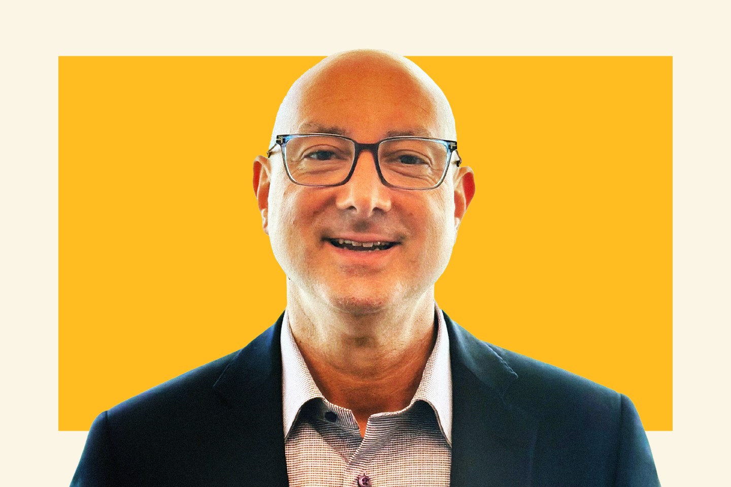 man in suit jacket and glasses smiling at camera