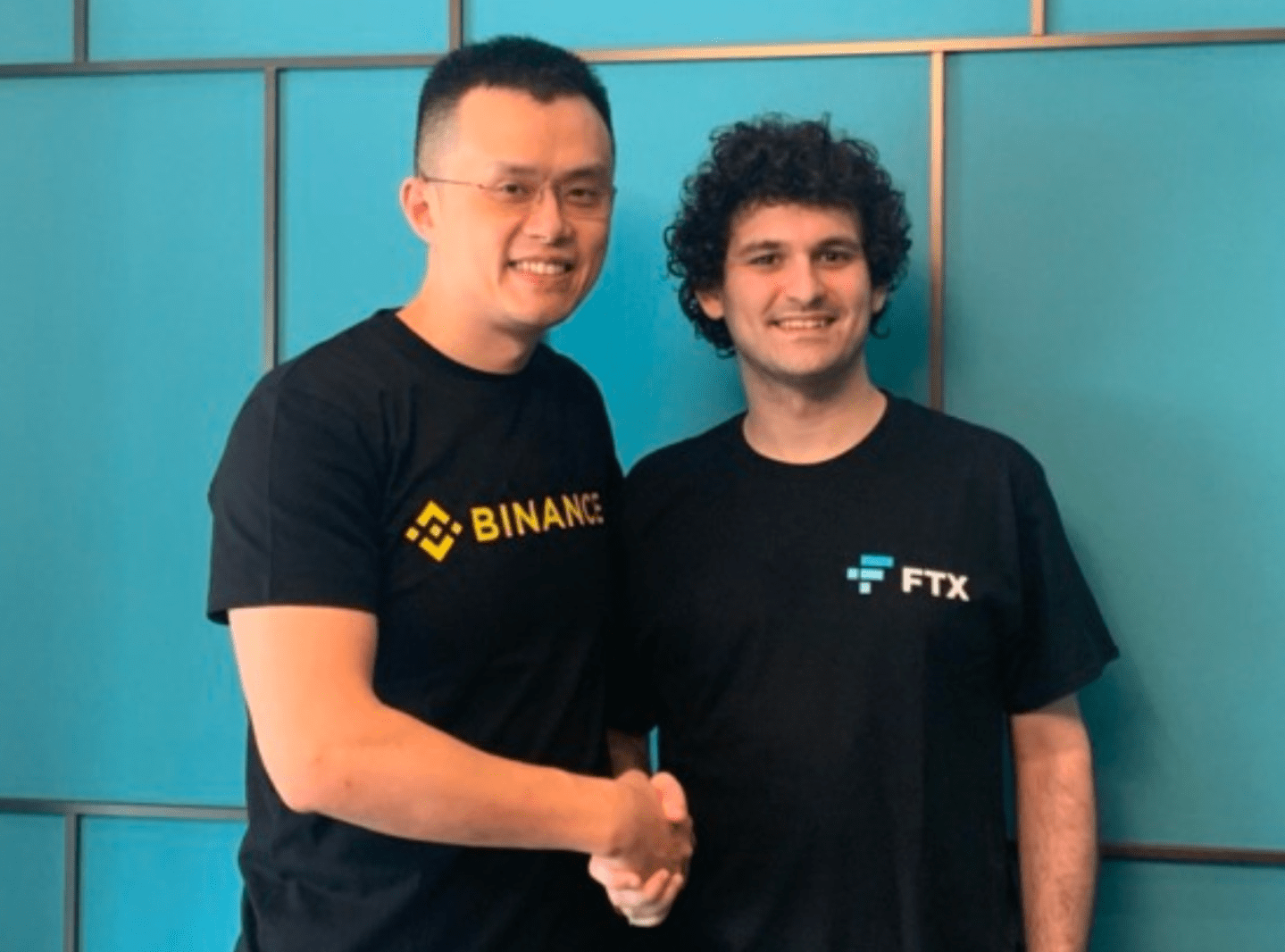 two men in t-shirts shaking hands