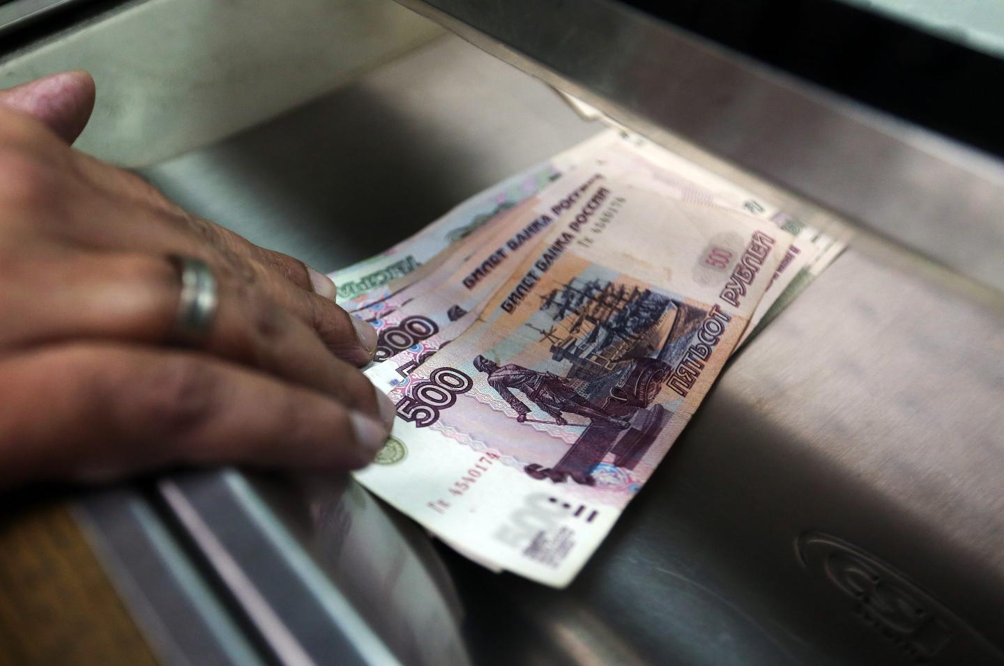 PERSON holding rouble notes