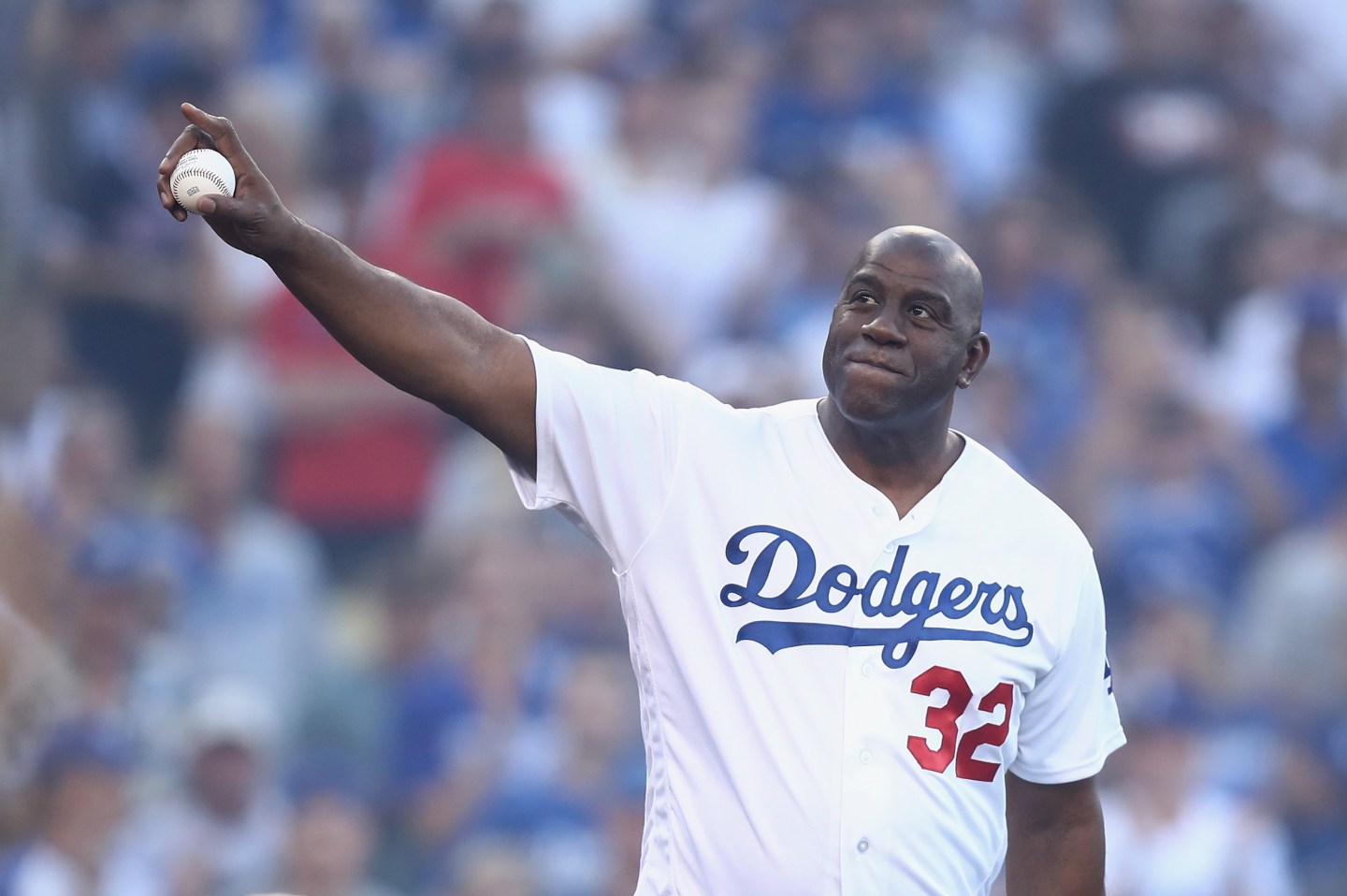 Magic Johnson waves to the fans before a game.