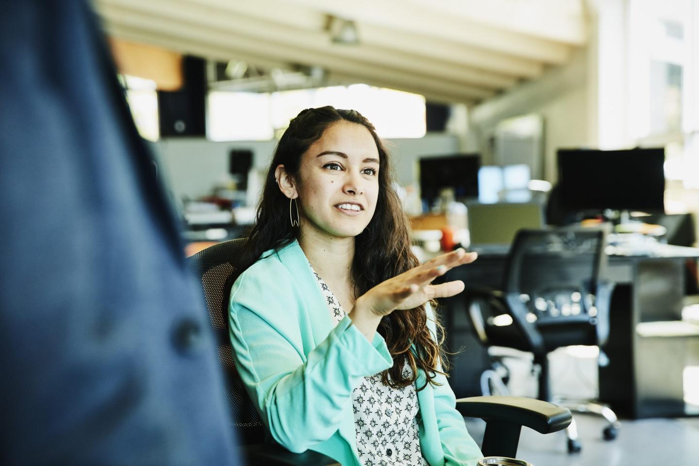 Young female worker in discussion with coworkers.