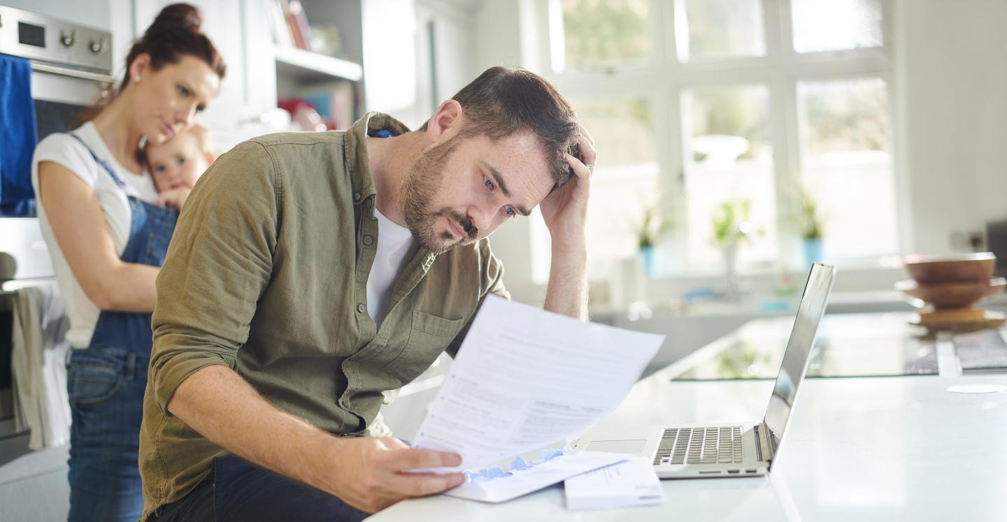 Photo of a young man looking seriously at a financial statement