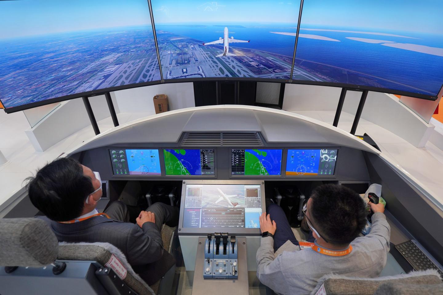 Visitors experience a flight simulator at the Honeywell booth during the China International Import Expo in Shanghai in November 2022.