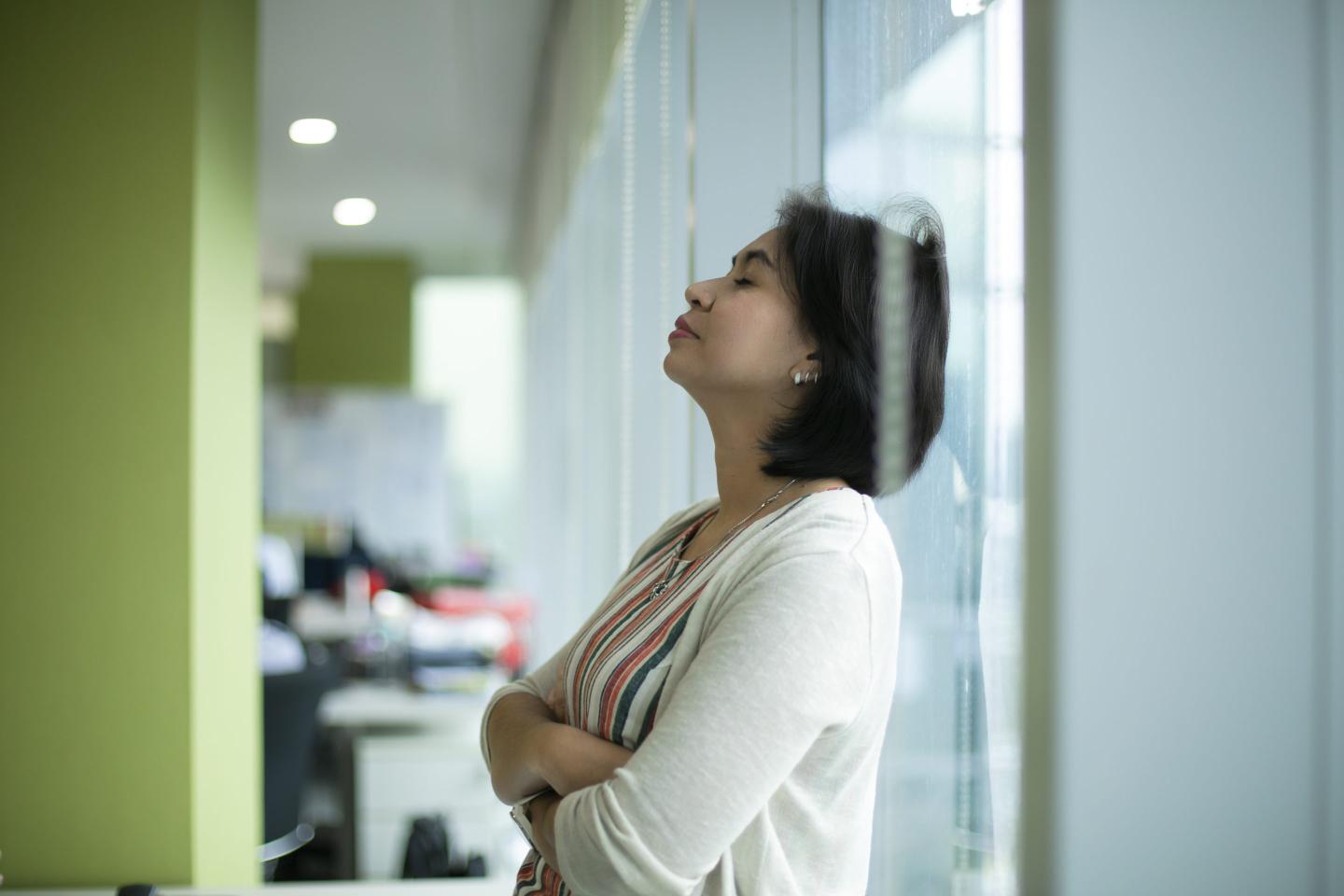woman leaning head against window