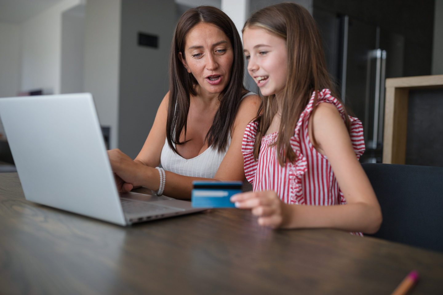Woman assisting her daughter on a online shopping spree