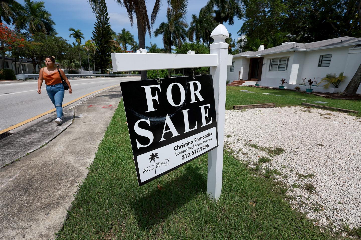 A “for sale” sign hangs in front of a home in Miami