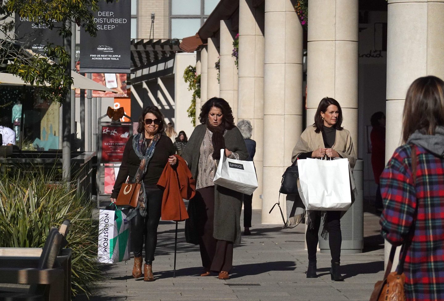 Women carry shopping bags while visiting the Village at Corte Madera on December 15, 2022 in Corte Madera, California.