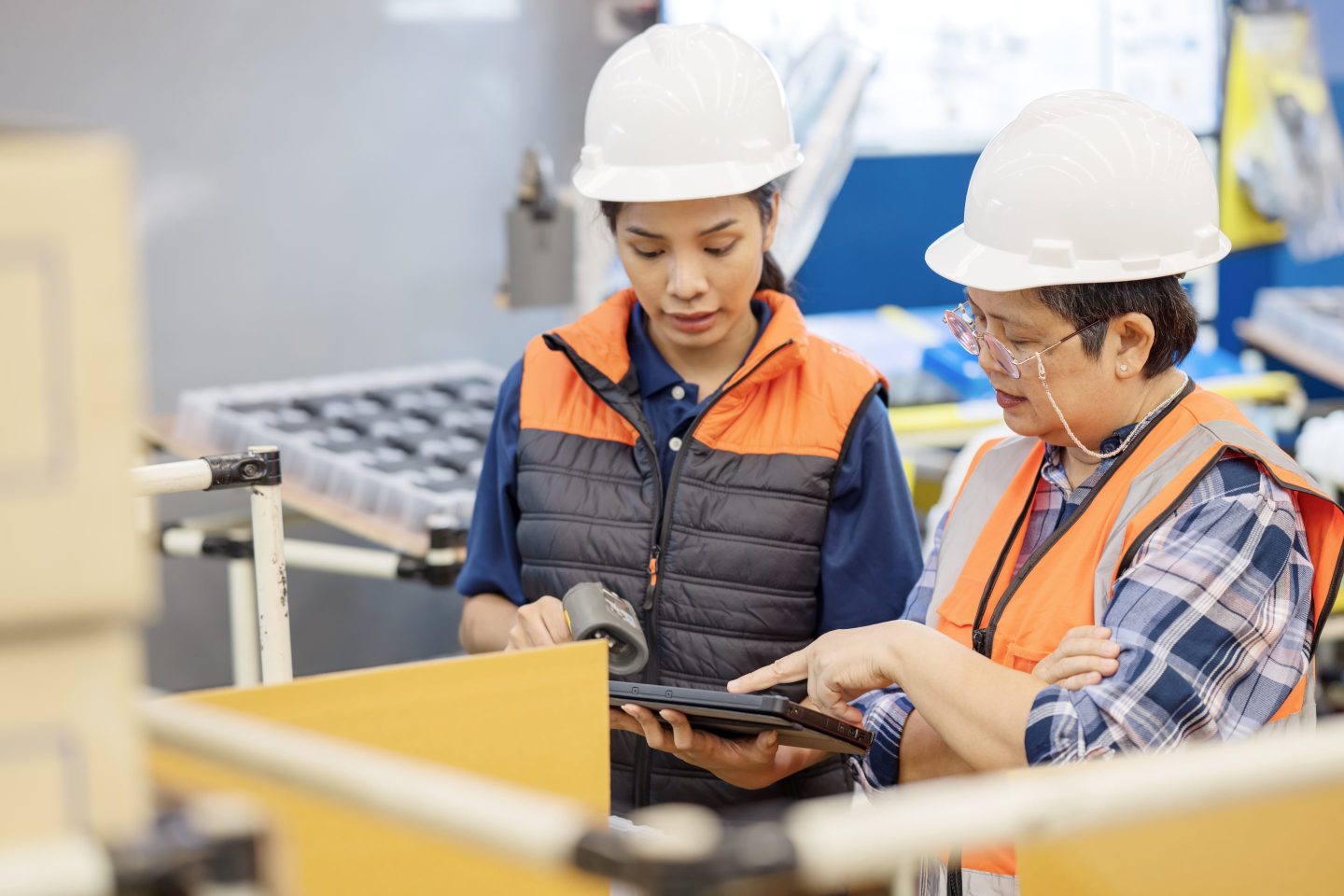 A Senior Quality Control Engineer had a discussion with an engineer over a tablet computer about product quality inspection standards on a factory production line.