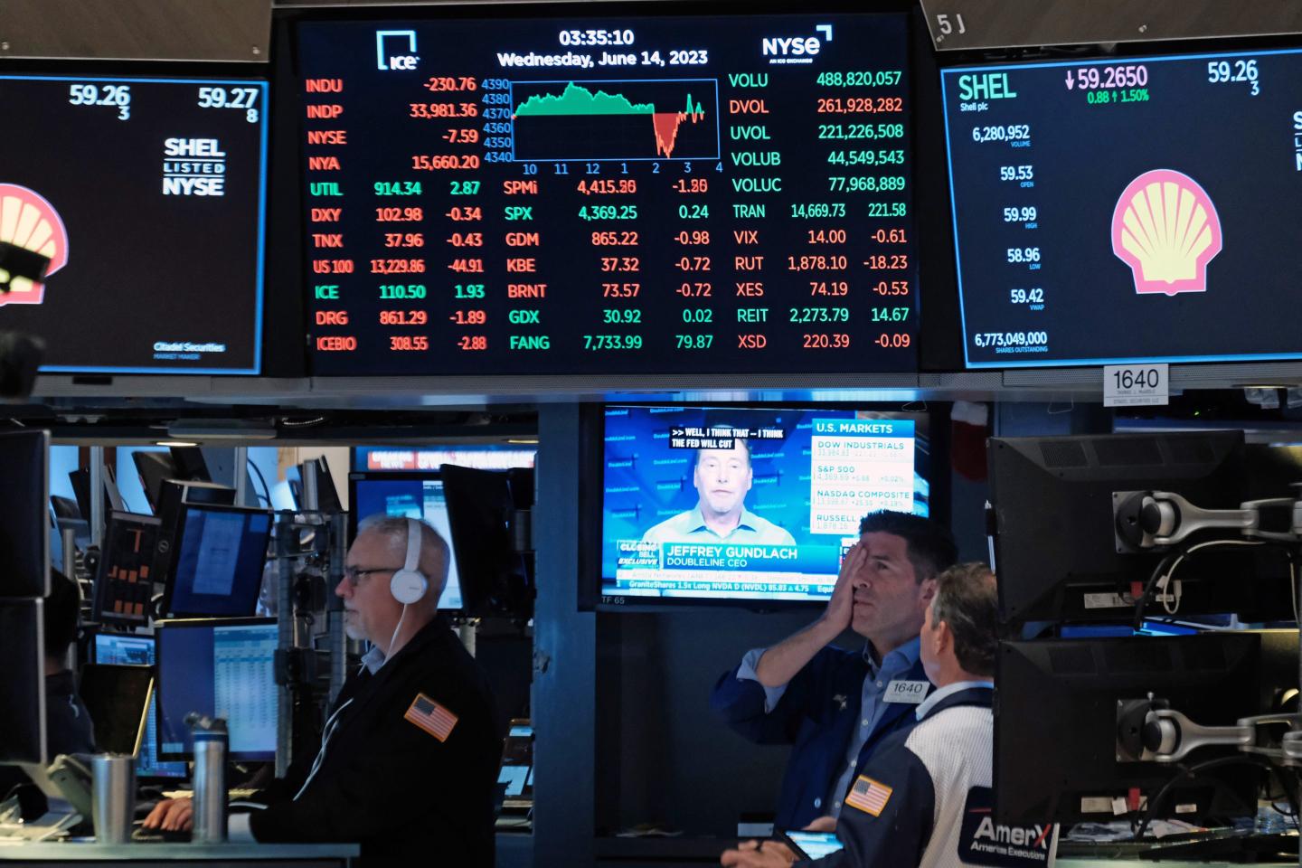 Traders work on the floor of the New York Stock Exchange on June 14, 2023 in New York City. One of them looks stressed.